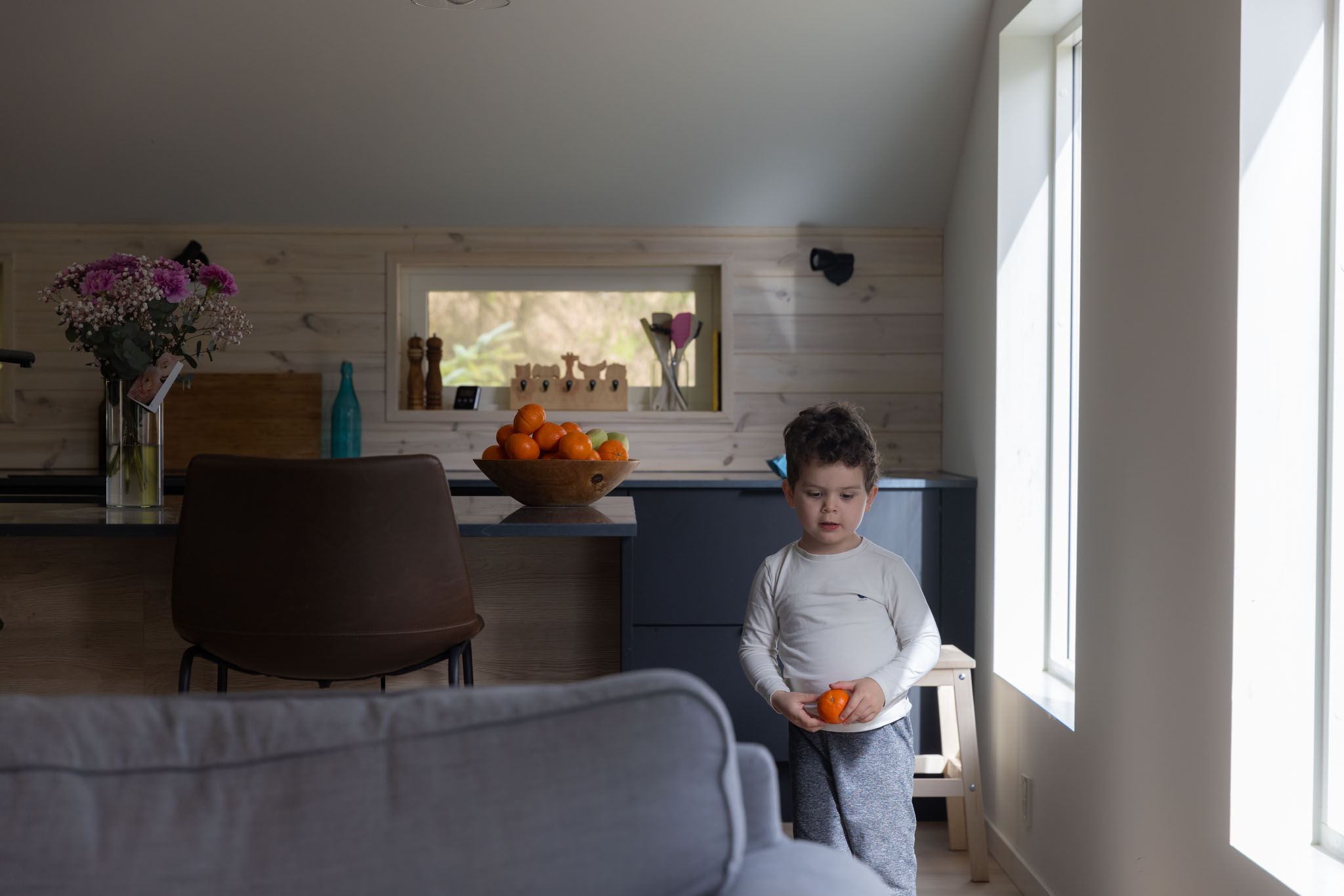 Når barn ikke samarbeider på familiefoto – slik foregår familiefotografering i Bergen når barna får være seg selv. Bilde av en liten gutt hjemme hos seg selv i stuen sin.