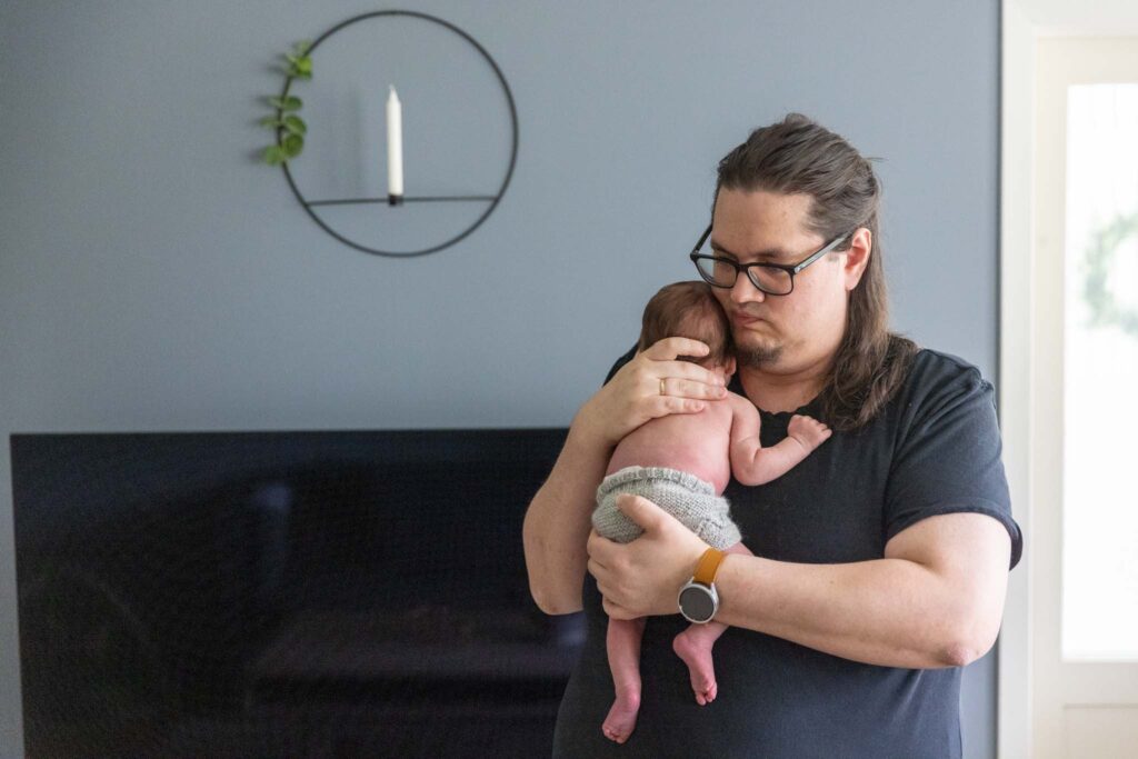 hjemmefotografering nyfødt Bergen. Far som holder nyfødt baby. 